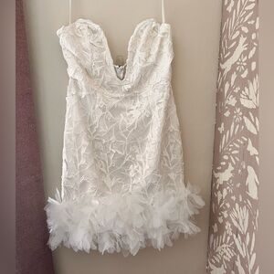 Selfie Leslie mini white dress with floral detail and ruffled bottom hem.